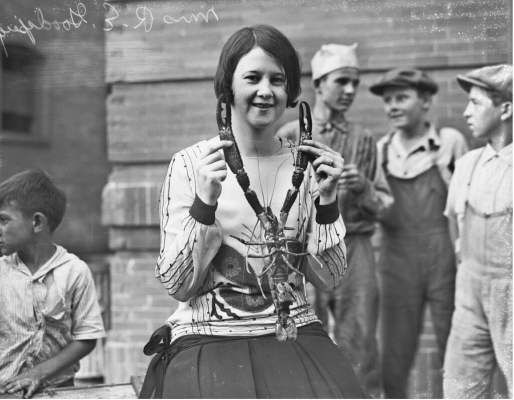 A woman holds a large shrimp taken out of San Pedro Creek