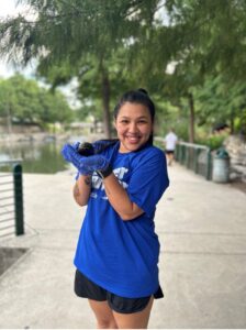 A Volunteer holds up an adult apple snail
