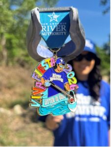 A woman holds a colorful fiesta medal