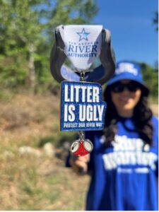 A woman holds a colorful fiesta medal