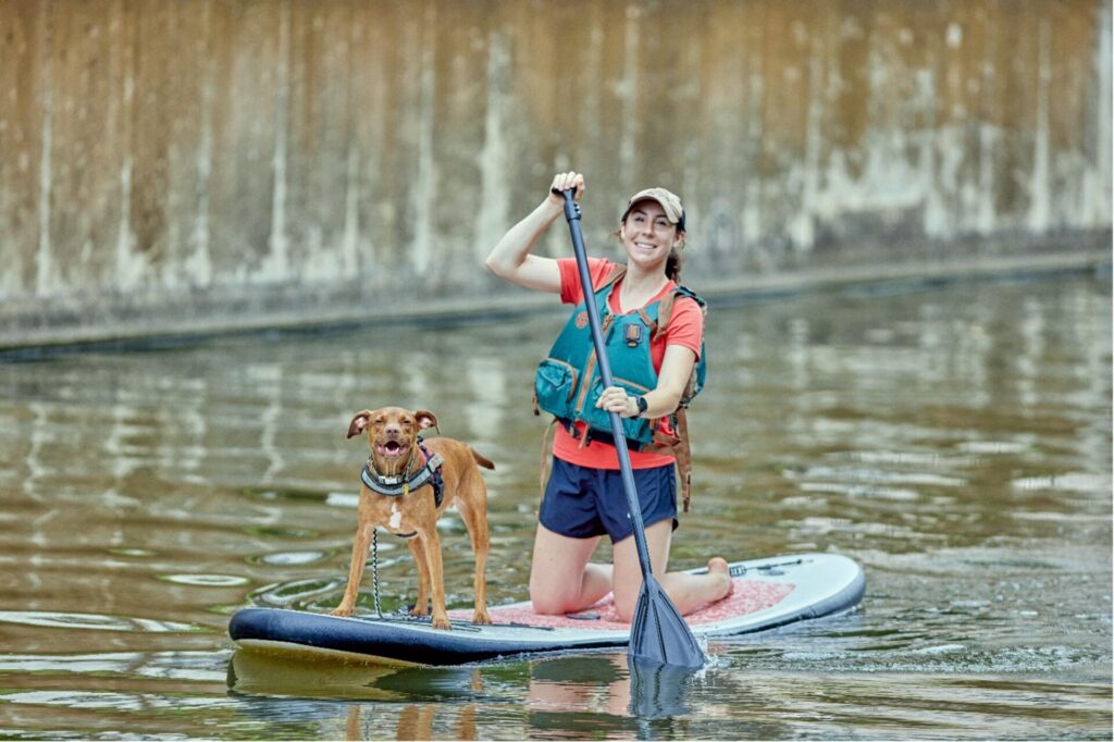 A woman and her dog paddle along the river in the King William neighborhood