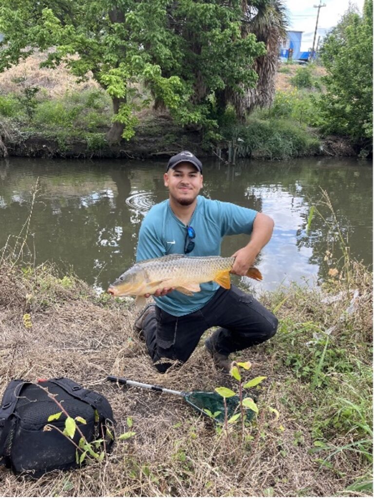 A man holds a large guadalupe bass