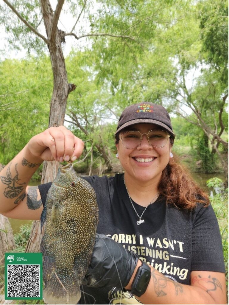 A woman holds up a fish