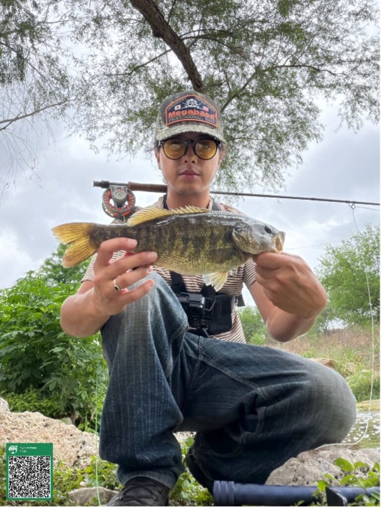 A boy holds up a fish