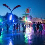 A water splashpad lit up at night