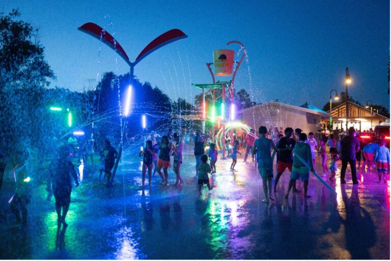 A water splashpad lit up at night