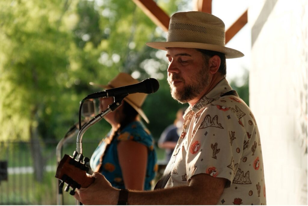 A musician sings into a microphone on stage