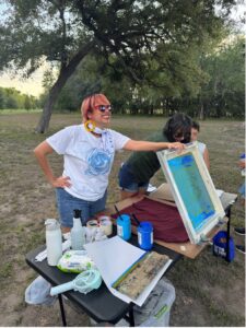 A woman proudly shows her work during cyanoprint workshop