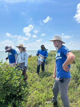 River Warriors look to the horizon during a beach cleanup.