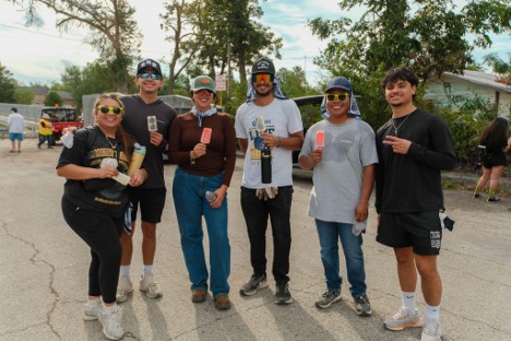 A group of volunteers pose together while enjoying paletas. 