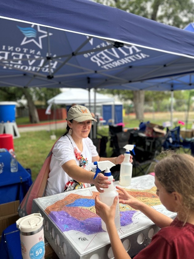 A child interacting with the watershed model at the Education table.