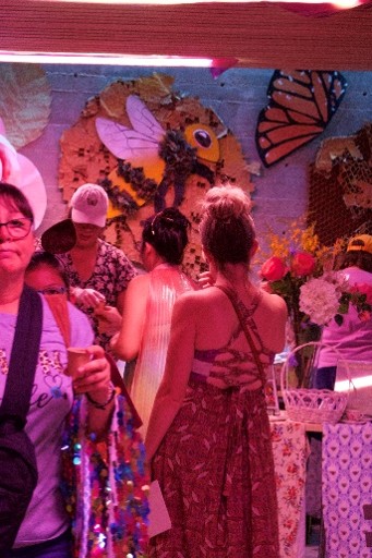 People gather in front of a pollinator mural.