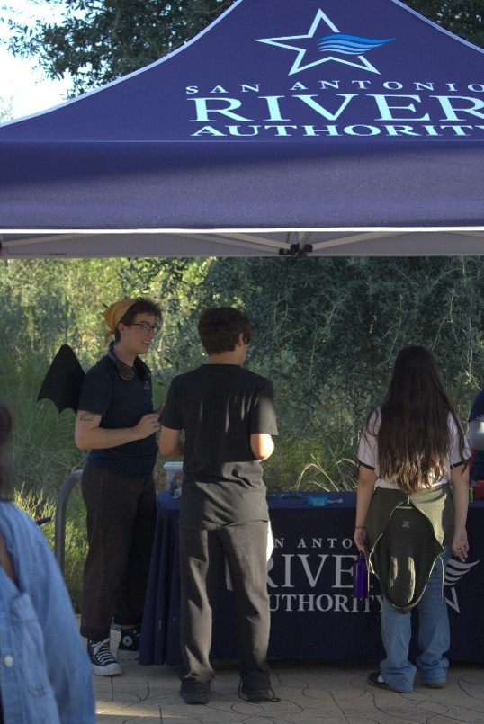People gather around the San Antonio River Authority table.