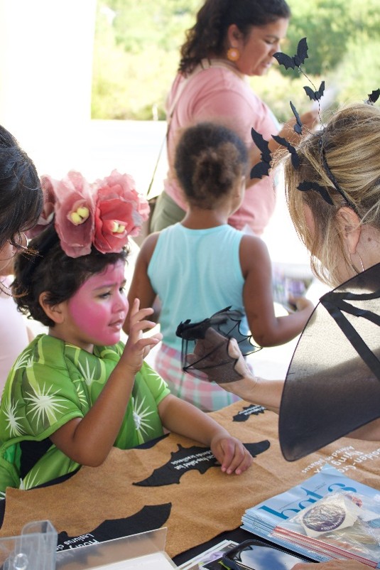 A child completes an activity at a festival booth.